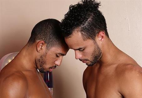 Mike Maverick and Javier Cruz tease each other with kisses as they pause to...